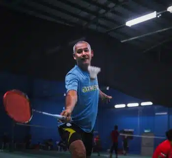 man in blue crew neck t-shirt and black shorts holding red basketball