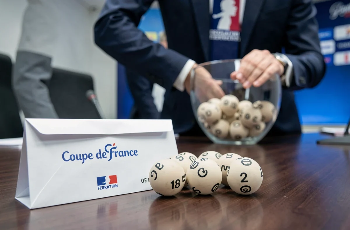 Tirage au sort officiel des demi-finales de la Coupe de France avec enveloppes et boules numérotées sur une table en bois lors d'une cérémonie officielle